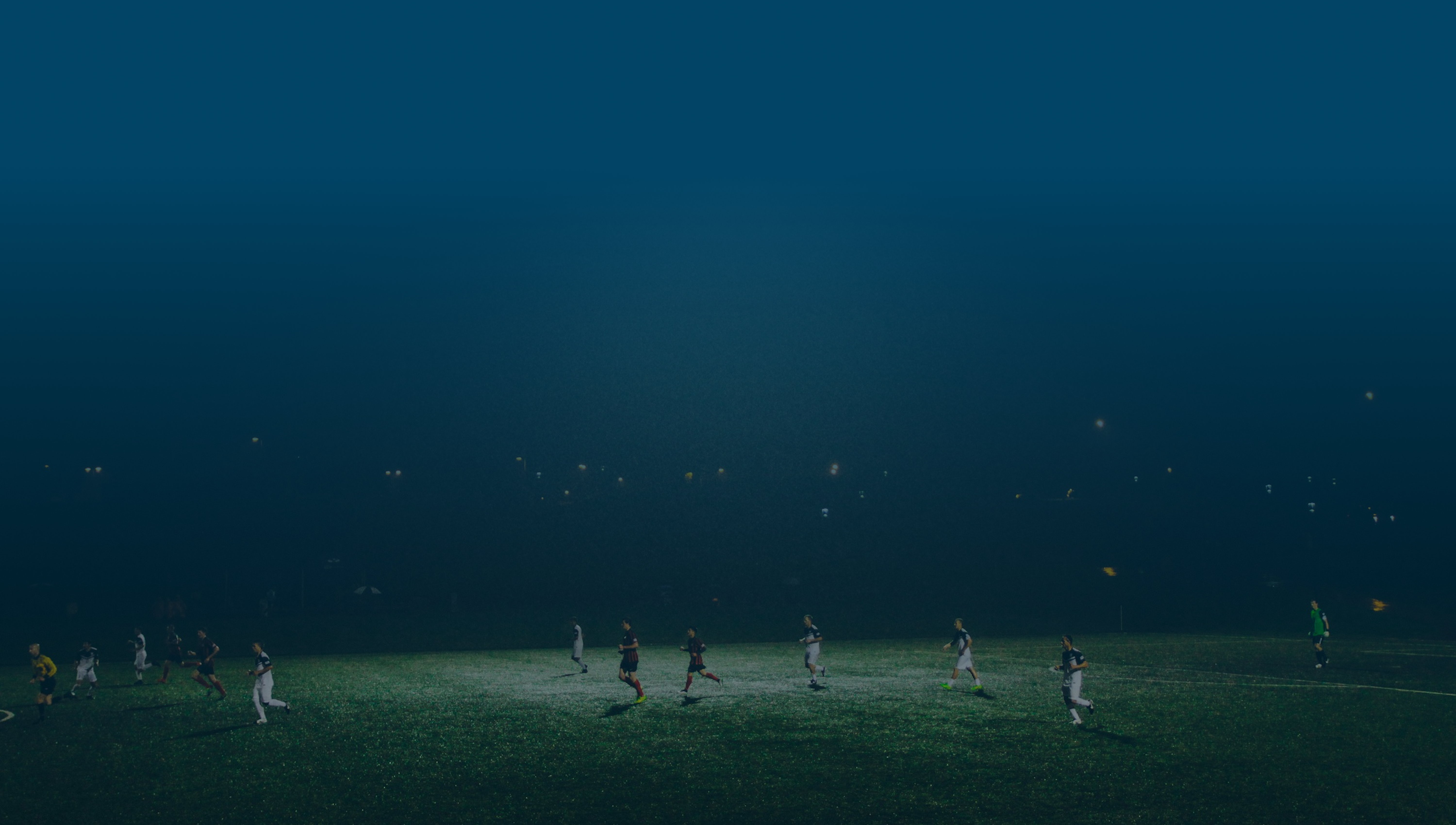 Cena de uma partida de futebol noturna.